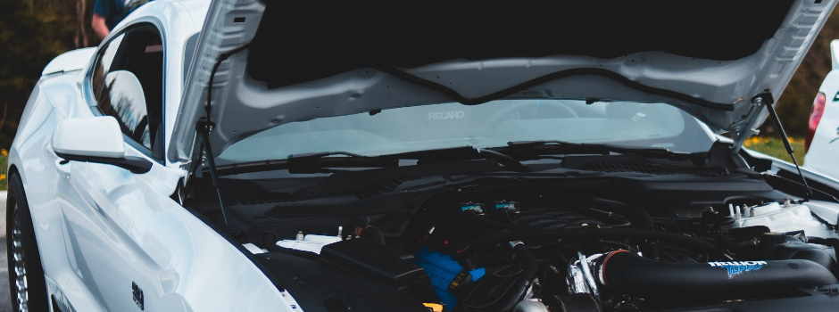 white car with hood open displaying engine